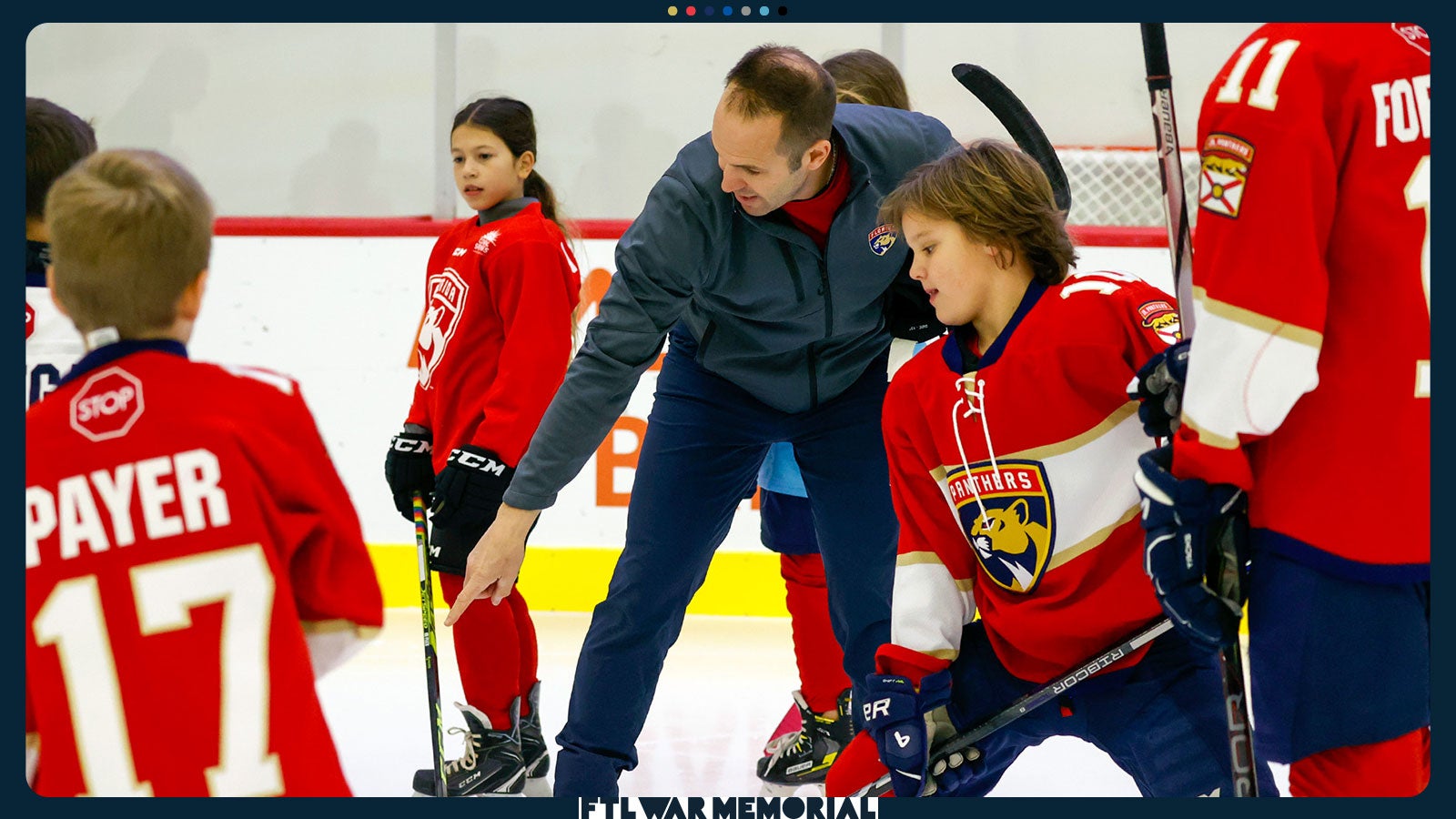 A photo of a hockey instructor directing a student during a camp at the Baptist Health IcePlex.